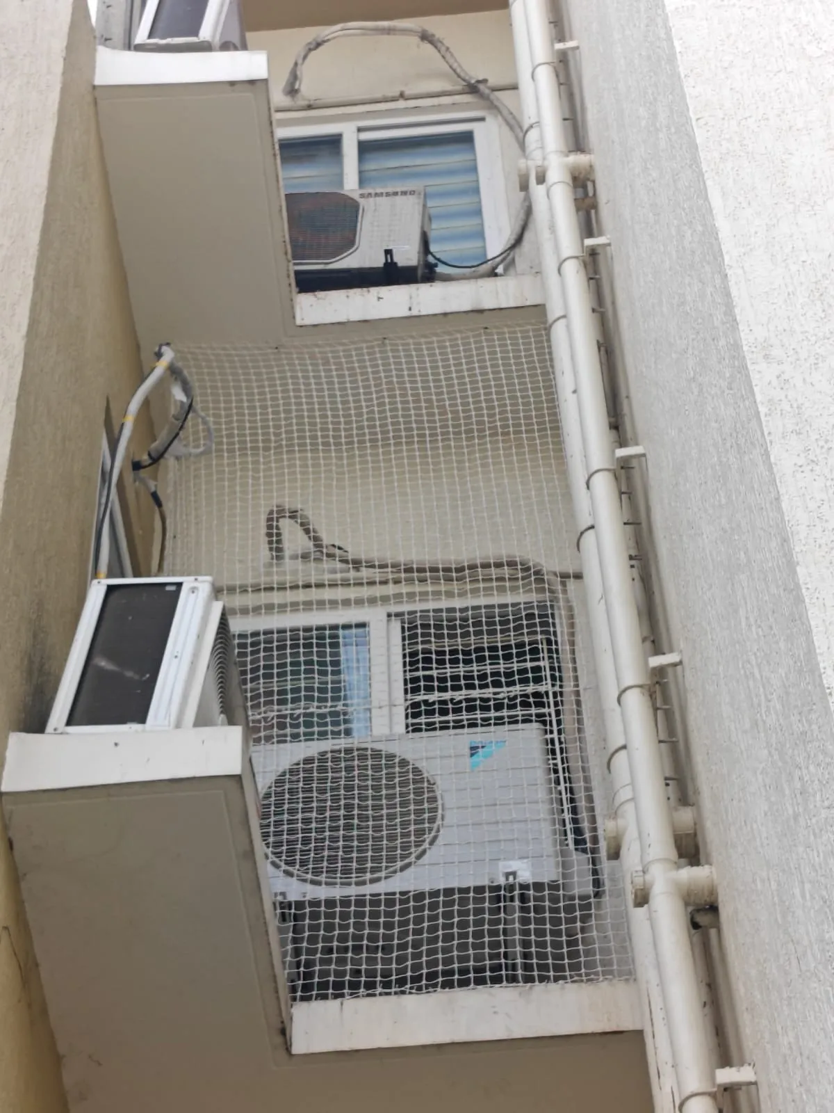 Bird net protecting air conditioner units in a building utility shaft