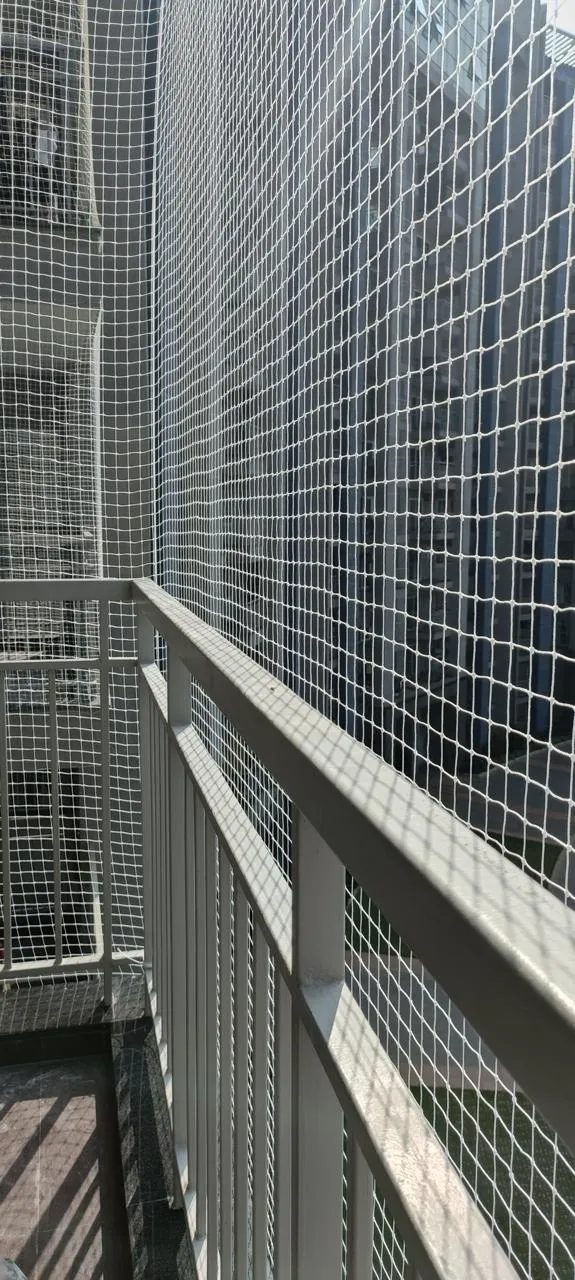 Bird net on a high-rise balcony overlooking neighbouring apartment towers