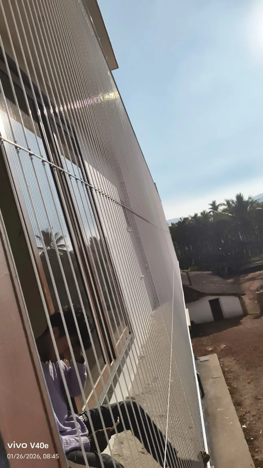 Invisible grill cables on a balcony overlooking neighbouring apartments