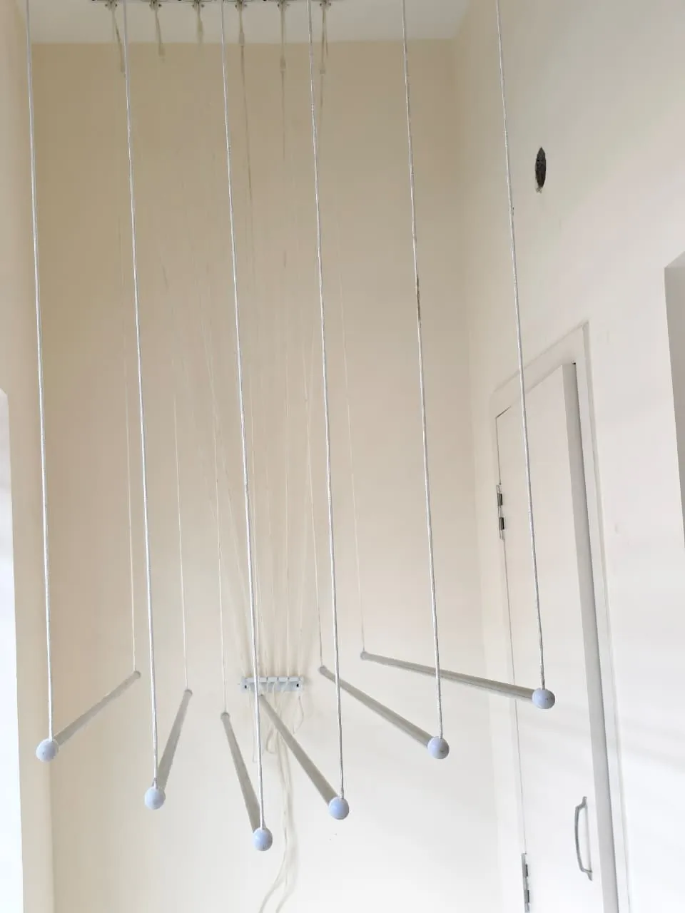 Ceiling cloth hanger rails lowered on nylon ropes in a utility area