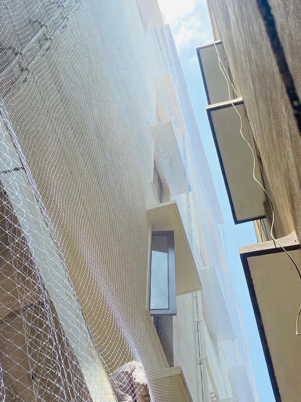 Bird net running along the full height of a building shaft between two towers
