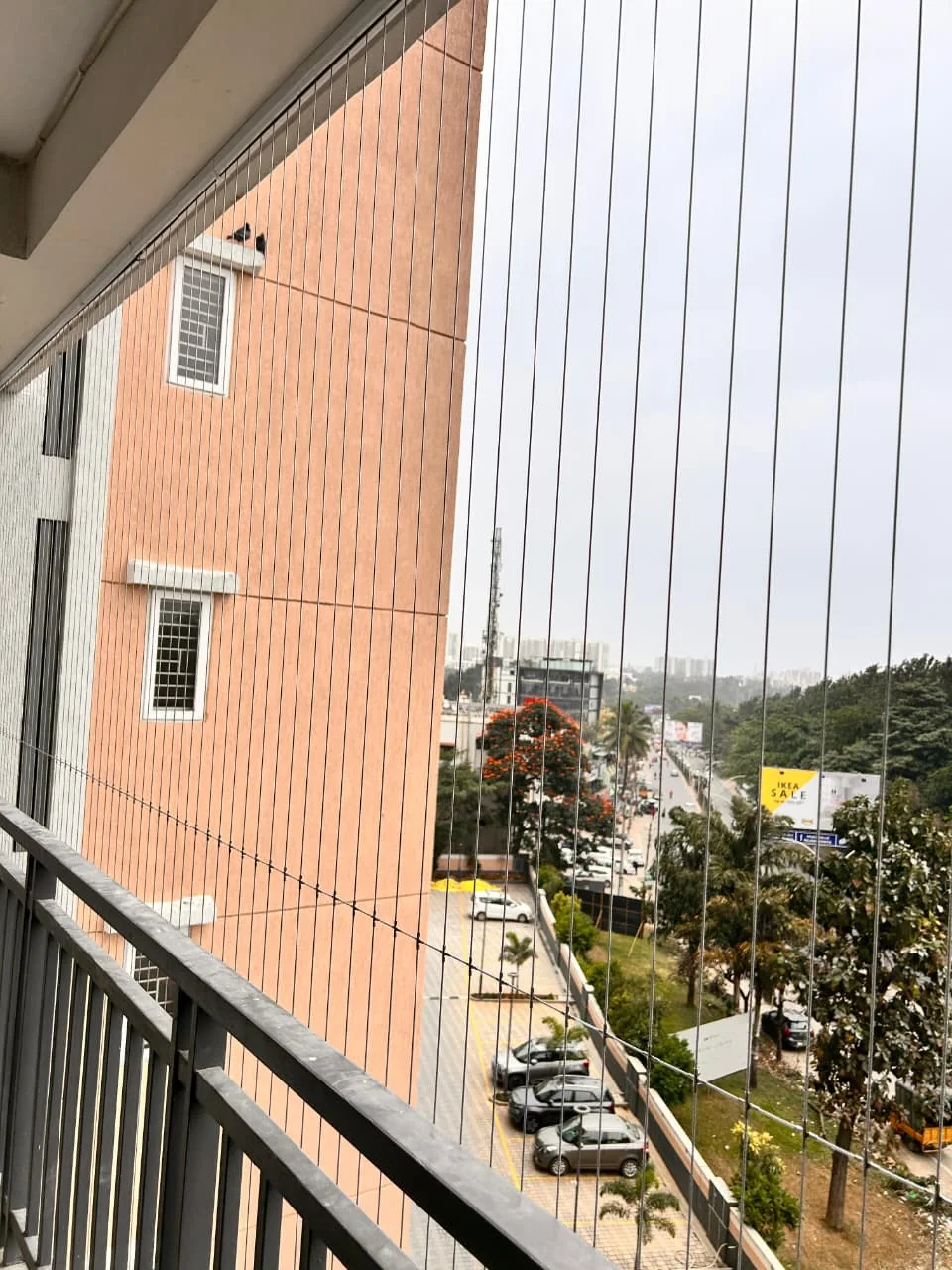Invisible grill fitted to an apartment balcony facing a main road