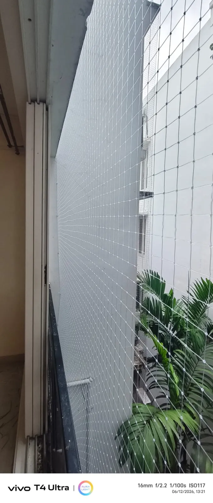 White nylon pigeon net stretched along a narrow apartment balcony