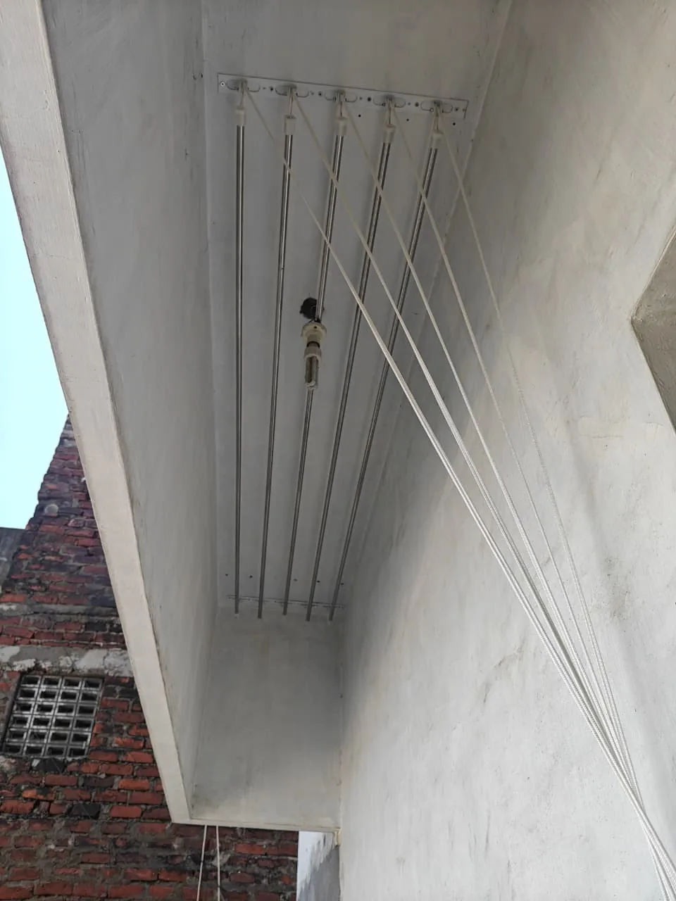 Five-rail cloth hanger fitted under a concrete balcony slab